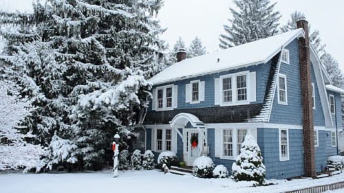 Blue house covered in snow after a large snow fall